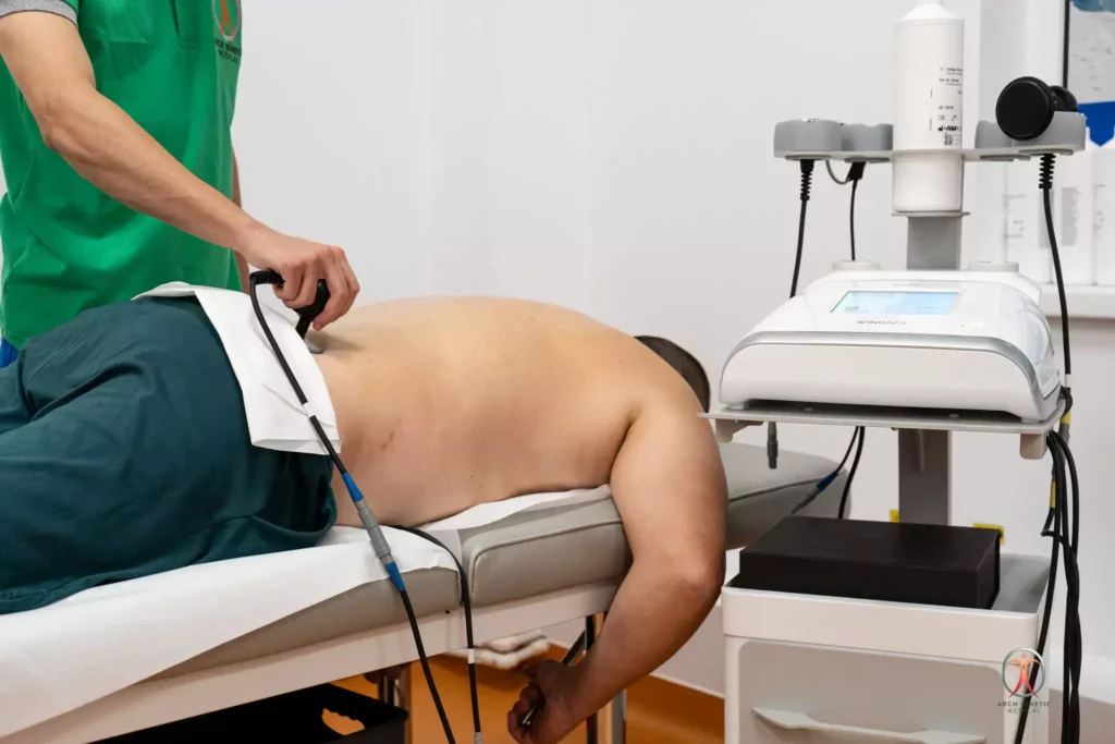 Fizioterapeut aplicand Terapia Tecar unui pacient cu dureri lombare la Arch Kinetic Medical Brasov.